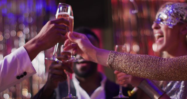 Image of happy, diverse group of friends toasting with glasses of champagne at a nightclub. Fun, drinking, going out, socialising and party concept.