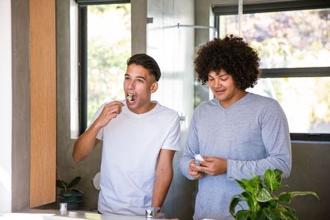 Friends Brushing Teeth Together in Modern Bathroom