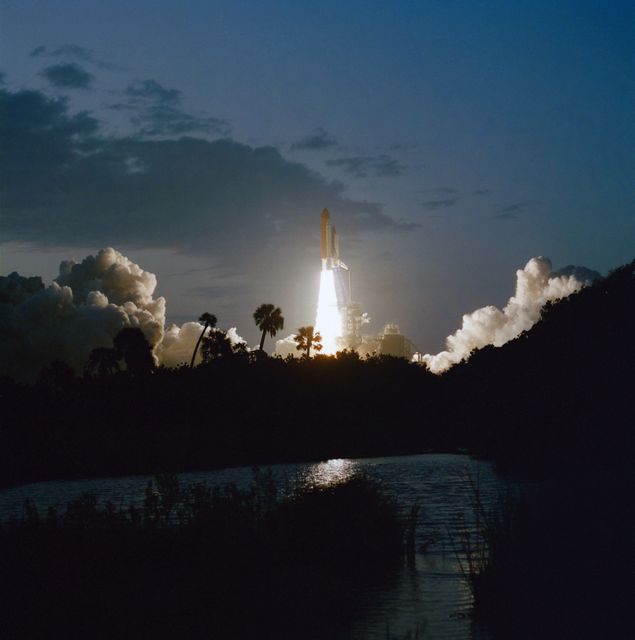 Dramatic imagery of Space Shuttle Endeavour launching into a dim dawn sky from Kennedy Space Center on April 9, 1994. Six astronauts onboard journey to Earth orbit for the Space Radar Laboratory mission. Perfect for articles, educational content on space exploration, or features on historic space missions.