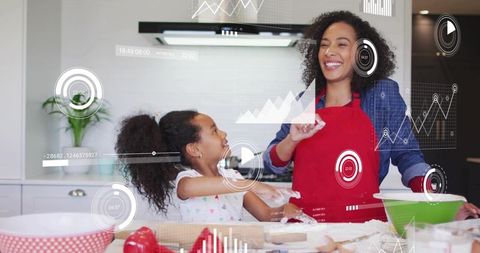 Baking and laughing: mother and daughter kneading dough with digital hud overlay