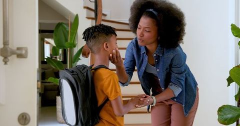 Caring Mother Talking to Son Before School
