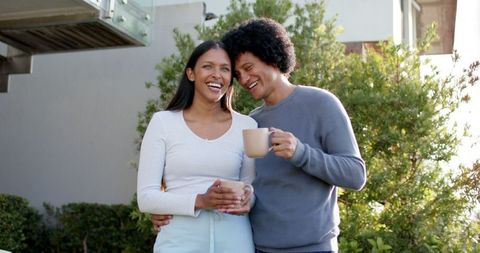 Happy Interracial Couple Enjoying Coffee in Modern Garden Space