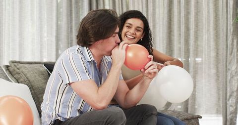 Joyful Couple Preparing for Birthday Party with Balloons at Home