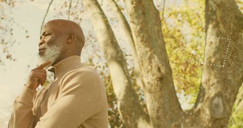 Elder man pondering in sunlit park portrait with dotted graphic overlay and copy space