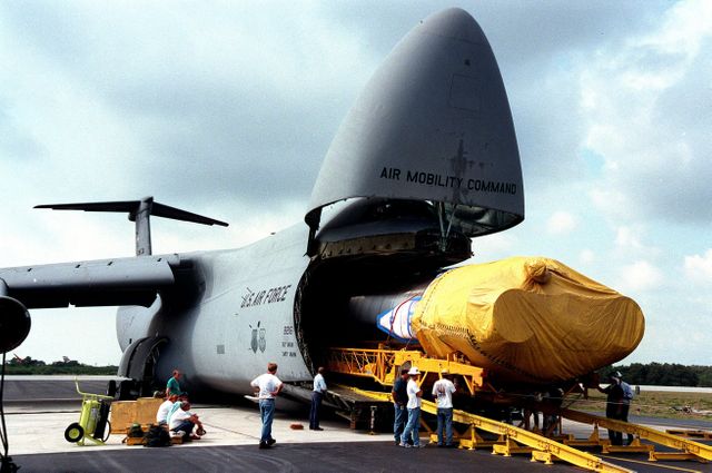 Image depicts workers starting to offload technically advanced Atlas IIA rocket from U.S. Air Force C-5c plane at Cape Canaveral Air Station. The rocket is set to launch the NASA GOES-L weather satellite. Useful for articles on space technology, logistics in aerospace, and NASA operations.