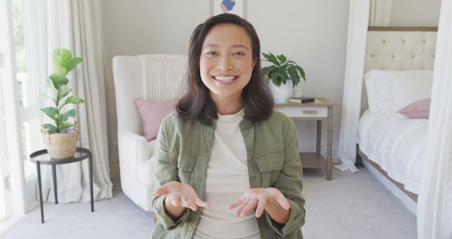 Smiling Woman Sitting in Modern Bedroom, Sharing Positive Message - Download Free Stock Images Pikwizard.com