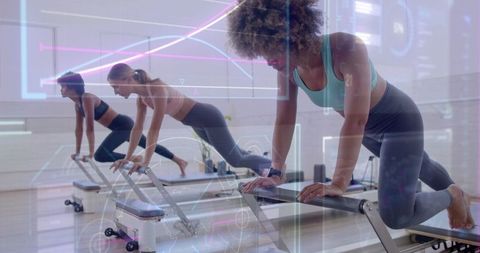 Women Exercising on Reformer Machines in Modern Fitness Studio