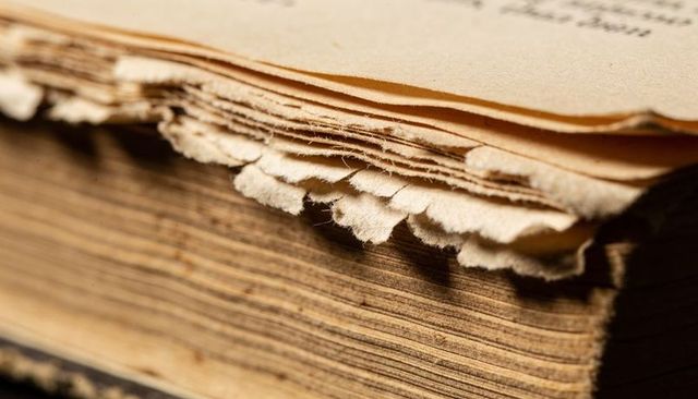 Revealing worn deckle-edged pages on antique book fore edge close-up macro texture