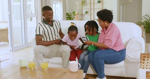 Joyful Family Celebrating Pregnancy Announcement with Tablet