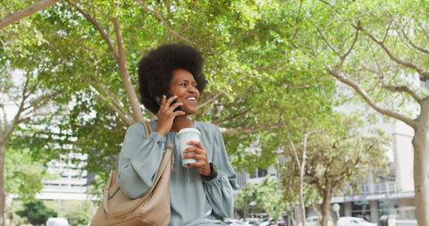 Businesswoman Enjoying Coffee Break in Urban Park with Smartphone