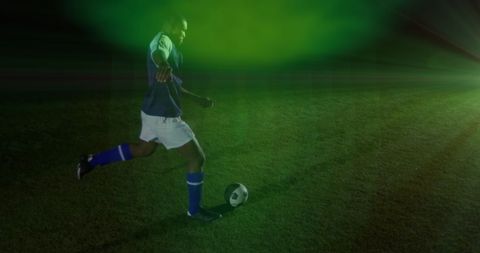 Soccer Player Kicking Ball with Green Light Effect Power and Motion