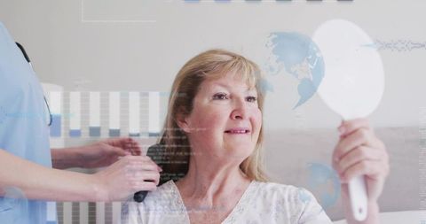 Senior woman holding mirror while caregiver brushing hair in serene care facility morning