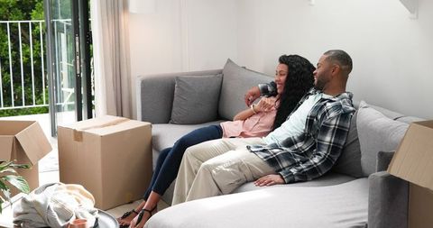 Happy Couple Enjoying New Home Surrounded by Moving Boxes