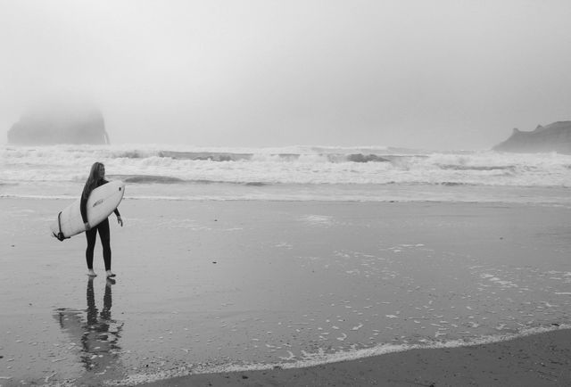 Surfer Carrying Surfboard on Foggy Beach - Download Free Stock Photos Pikwizard.com