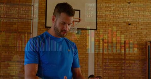 Basketball coach guiding player in gym with data overlay