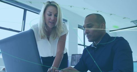 Collaborative Professionals Analyzing Data on Laptop in Modern Office