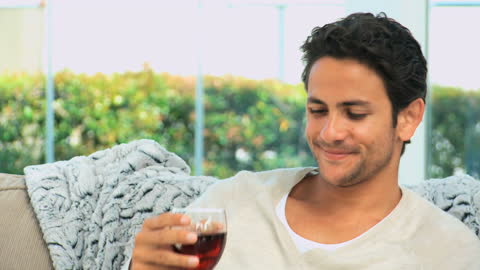 Young Man Enjoying Red Wine in Relaxed Home Setting
