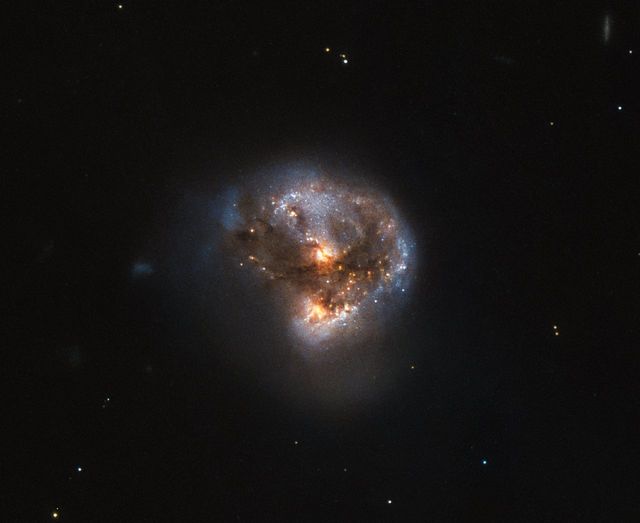 This image displays the megamaser galaxy IRAS 16399-0937 located over 370 million light-years from Earth. Shown by the Hubble Space Telescope, this galaxy contains a double nucleus consisting of a starburst region and a LINER nucleus, the latter hosting a massive black hole. The image is ideal for articles or educational materials around topics of galaxy formation, space telescopes, or astrophysical phenomena. Educational platforms, science communicators, and space enthusiasts can use this vibrant depiction to elucidate the dynamics within galaxies.