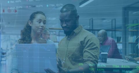 Professionals analyzing financial data on laptop in modern office