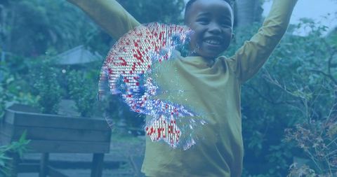 Smiling child raising arms in backyard with augmented reality blue-red digital swirl
