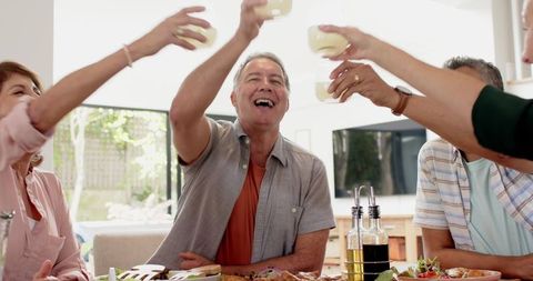 Smiling Family Enjoying Toast Around Dining Table