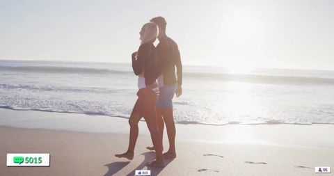 Romantic Couple Strolling on Sandy Beach at Sunset