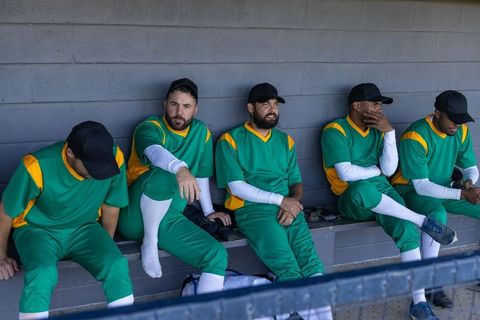 Baseball team sitting in dugout checking phone between innings with animated stats overlay