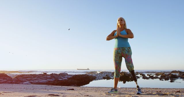 Determined Woman with Prosthetic Leg Meditating on Beach at Sunrise - Download Free Stock Images Pikwizard.com