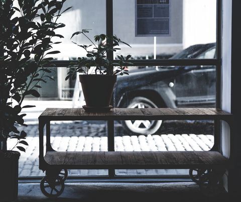 Urban window view with potted plants and rustic table
