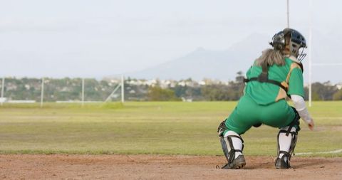 Female softball catcher in action behind home plate