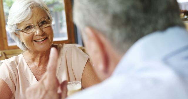 Smiling Senior Woman Engaging in Conversation with Friend at Coffee Shop - Download Free Stock Images Pikwizard.com