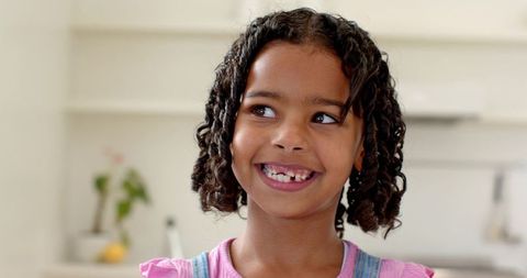 Cheerful girl smiling in bright home kitchen