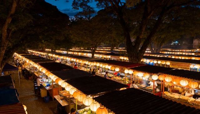 Lantern-lined night market rows drawing crowds to bustling outdoor street food stalls