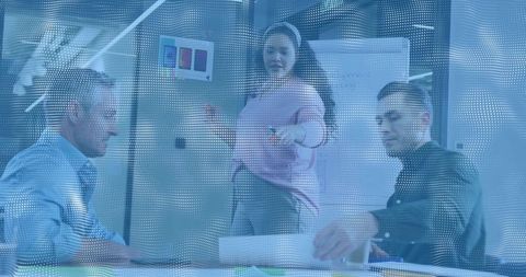 Woman presenting in glass meeting room leading collaborative team brainstorming and strategy session