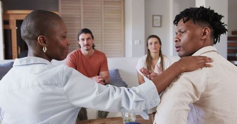 Woman comforting friend in group discussion setting