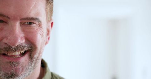 Man with Stubble Beard Smiling Brightly in Light Home Interior