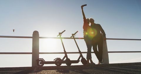 Senior Couple Taking Selfie with Scooters at Sunrise