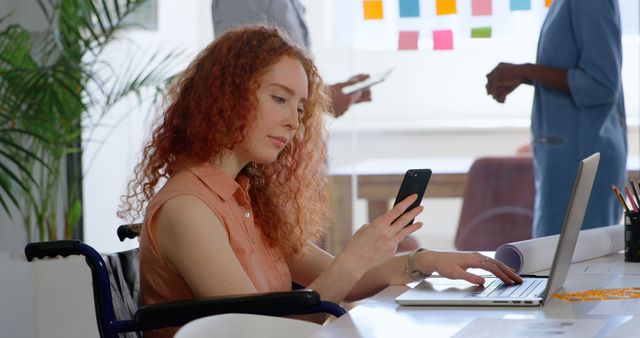 Young Professional with Red Curly Hair Working on Laptop and Smartphone in Office - Download Free Stock Images Pikwizard.com