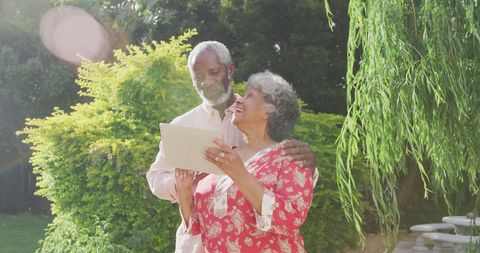 Senior Biracial Couple Enjoying Technology Outdoors in a Sunny Garden - Download Free Stock Images Pikwizard.com