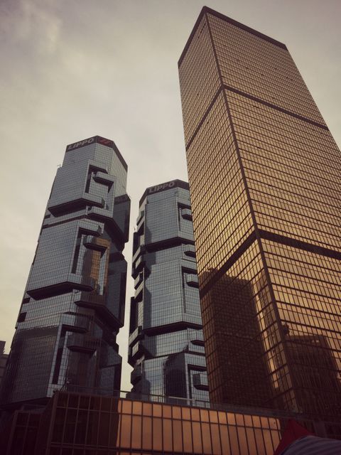 Featuring distinctive architectural designs, these skyscrapers in a bustling urban financial district are well-suited for use in publications and websites focusing on urban development, corporate settings, international business hubs, and modern architectural trends. They represent advanced engineering and contemporary city living.