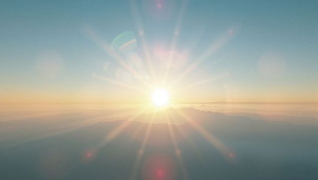 Golden Sun with Radiant Beams Over Mountain Ridge at Dawn
