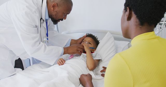 African american male doctor examining child patient at hospital. Medicine, healthcare, lifestyle and hospital concept.