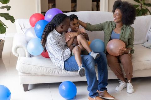 African american family celebrating at home with colorful balloons and joyful laughter