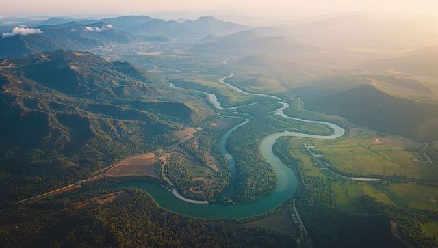 Aerial View of Winding River through Verdant Valley and Countryside