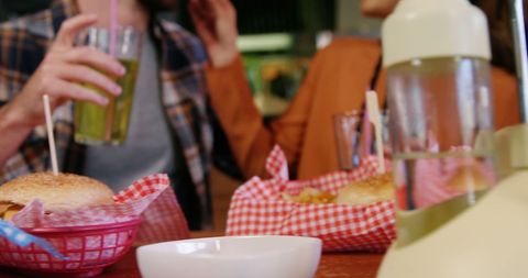 Friends enjoying drinks and burgers at casual diner