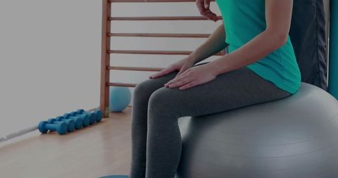 Woman Balancing on Stability Ball in Gym for Fitness and Rehabilitation