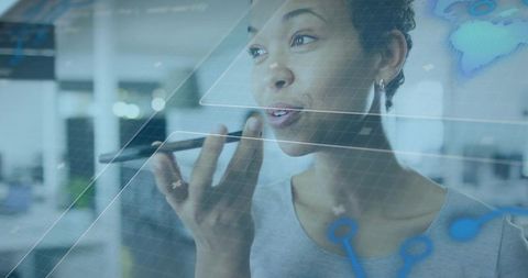 Speaking into smartphone, interacting with holographic data overlay in futuristic office