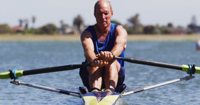 Senior caucasian man rowing boat on a river. sport retirement leisure hobbies rowing healthy outdoor lifestyle.