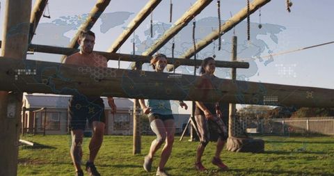 Team carrying heavy log during outdoor obstacle course endurance challenge