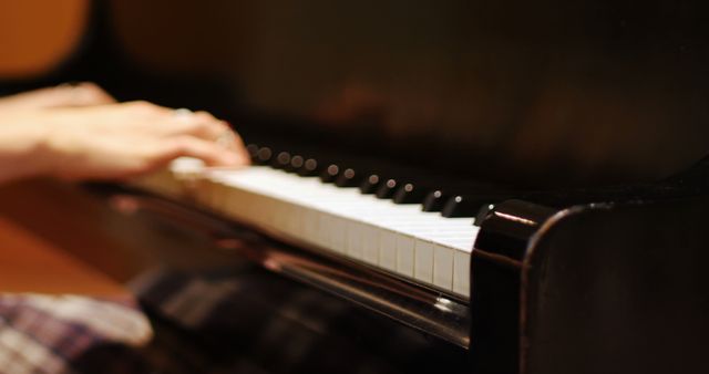 Mid section of woman playing a piano in music studio